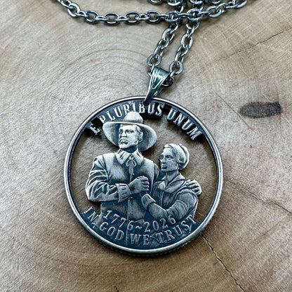 U.S. 2026 "Pilgrim" Quarter Hand Cut Coin Necklace with a stainless chain on a wood round. -Mountainstruck Coin Jewelry