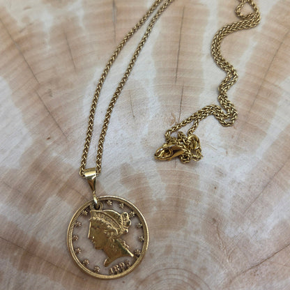 U.S. 22k Gold Half Eagle Hand Cut Necklace on a wood background. - Mountainstruck Coin Jewelry