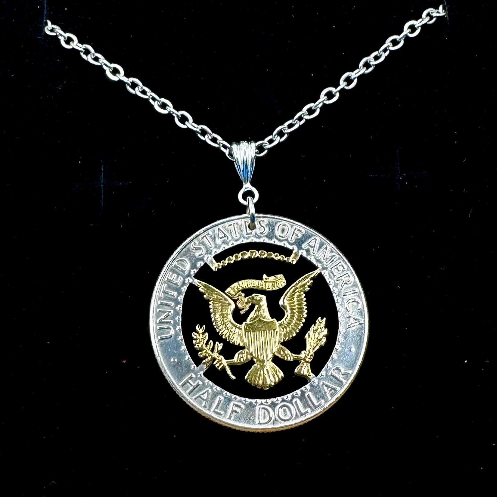 U.S. JFK Eagle Half Dollar Hand Cut Silver Coin Necklace with 24k gold plated Eagle on a black velvet background. - Mountainstruck Coin Jewelry