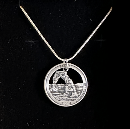 U.S. Arches National Park Coin Necklace on a black velvet background. - Mountainstruck Coin Jewelry
