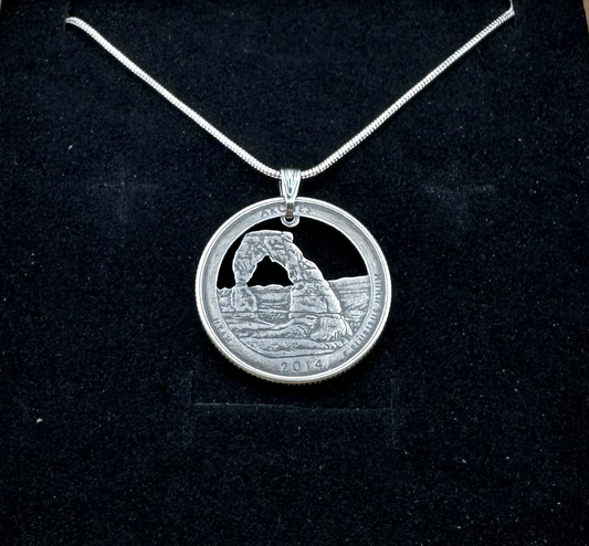 U.S. Arches National Park Hand Cut Coin Necklace with snake chain on a black velvet background. - Mountainstruck Coin Jewelry