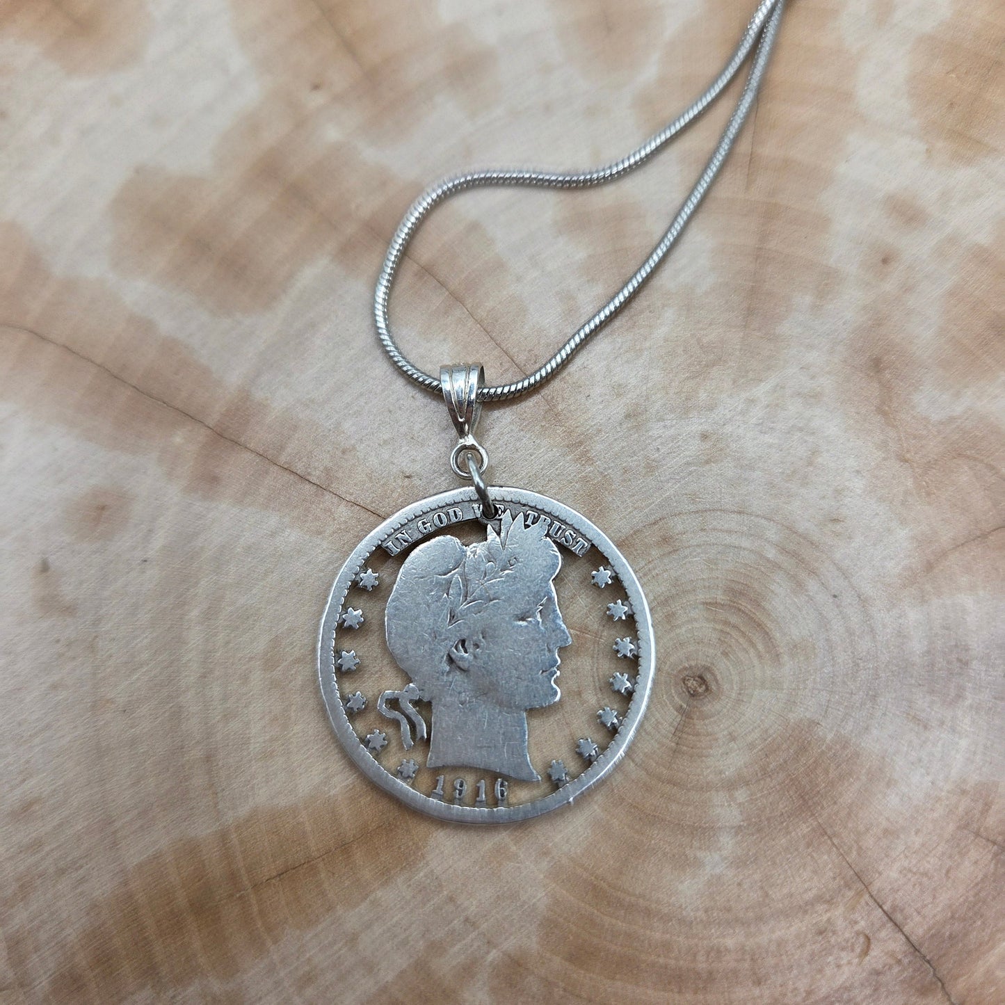 U.S. Barber Quarter Hand Cut Silver Coin Necklace with a snake chain on a wood background. -Mountainstruck Coin Jewelry