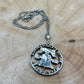Cracked Liberty Bell U.S. Half Dollar Hand Cut Coin Necklace with stainless chain on a wood background. - Mountainstruck Coin Jewelry