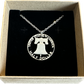 U.S. Cracked Liberty Bell Half Dollar Hand Cut Coin Necklace with a stainless chain in a brown kraft box on a black velvet background. - Mountainstruck Coin Jewelry