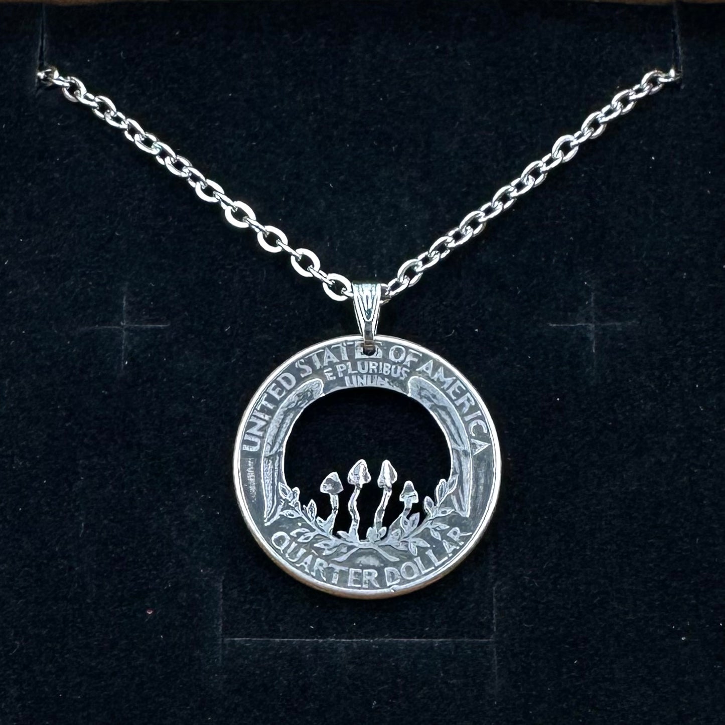 U.S. Custom Mushroom Quarter Hand Cut Coin Necklace with stainless chain on a black velvet background.- Mountainstruck Coin Jewelry