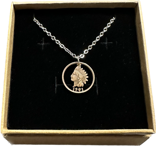 U.S. Indian Head Penny Hand Cut Coin Necklace with a stainless chain in a brown kraft box on a black velvet background. - Mountainstruck Coin Jewelry