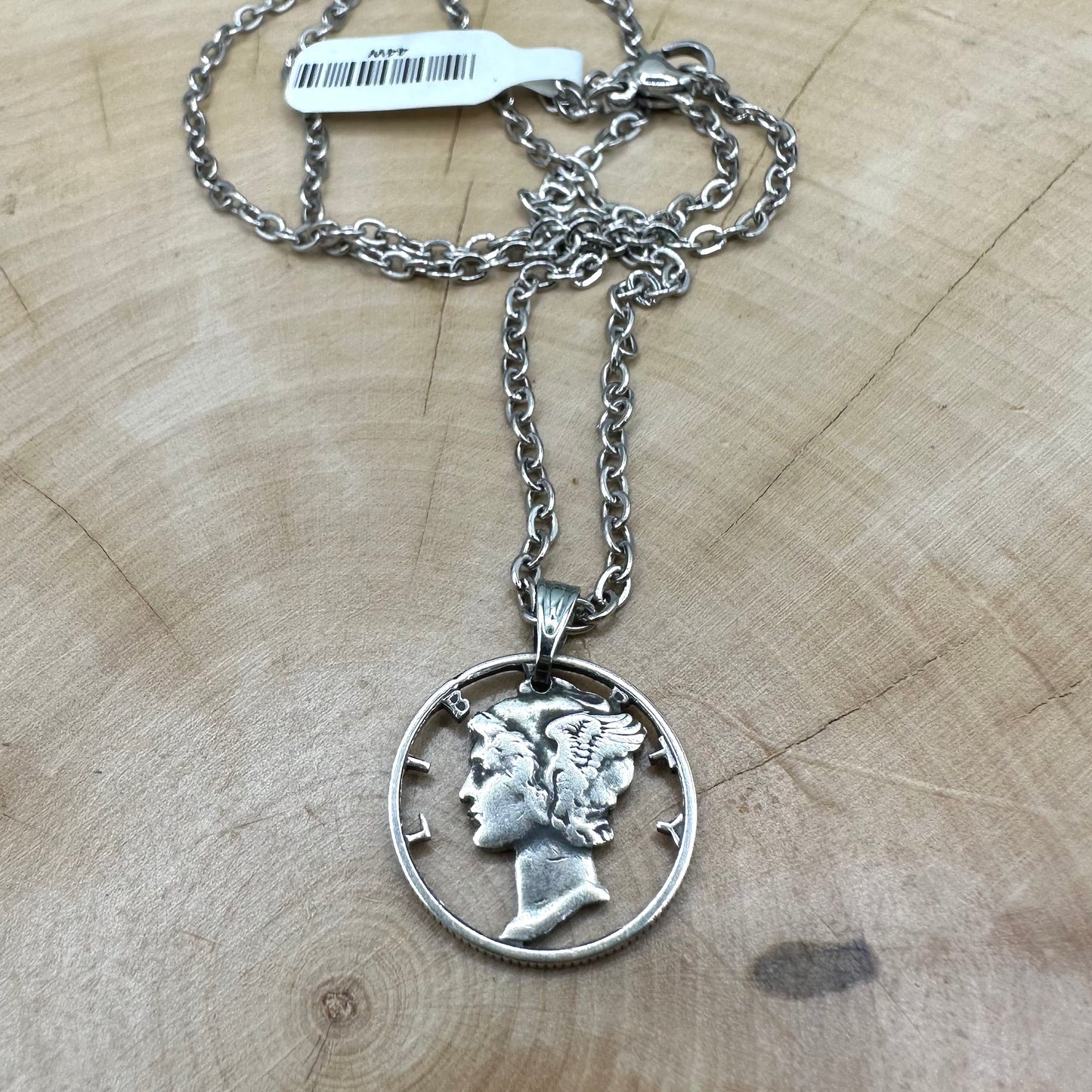 U.S. Mercury Dime Silver Hand Cut Coin Necklace (stainless chain) in a brown kraft box on a wood background. - Mountainstruck Coin Jewelry