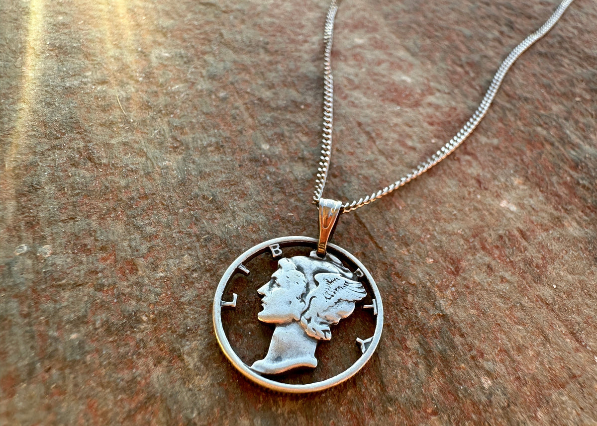 U.S. Mercury dime Hand Cut Silver coin Necklace on a red flagstone rock background. - Mountainstruck Coin Jewelry