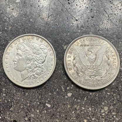 U.S. Morgan Silver Dollar Coin on concrete background. Front side of coin on left side of picture and back side on right. - Mountainstruck Coin Jewelry