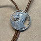 U.S. Silver Eagle Hand Cut Coin Bolo Tie close up on a light cloth background. - Mountainstruck Coin Jewelry