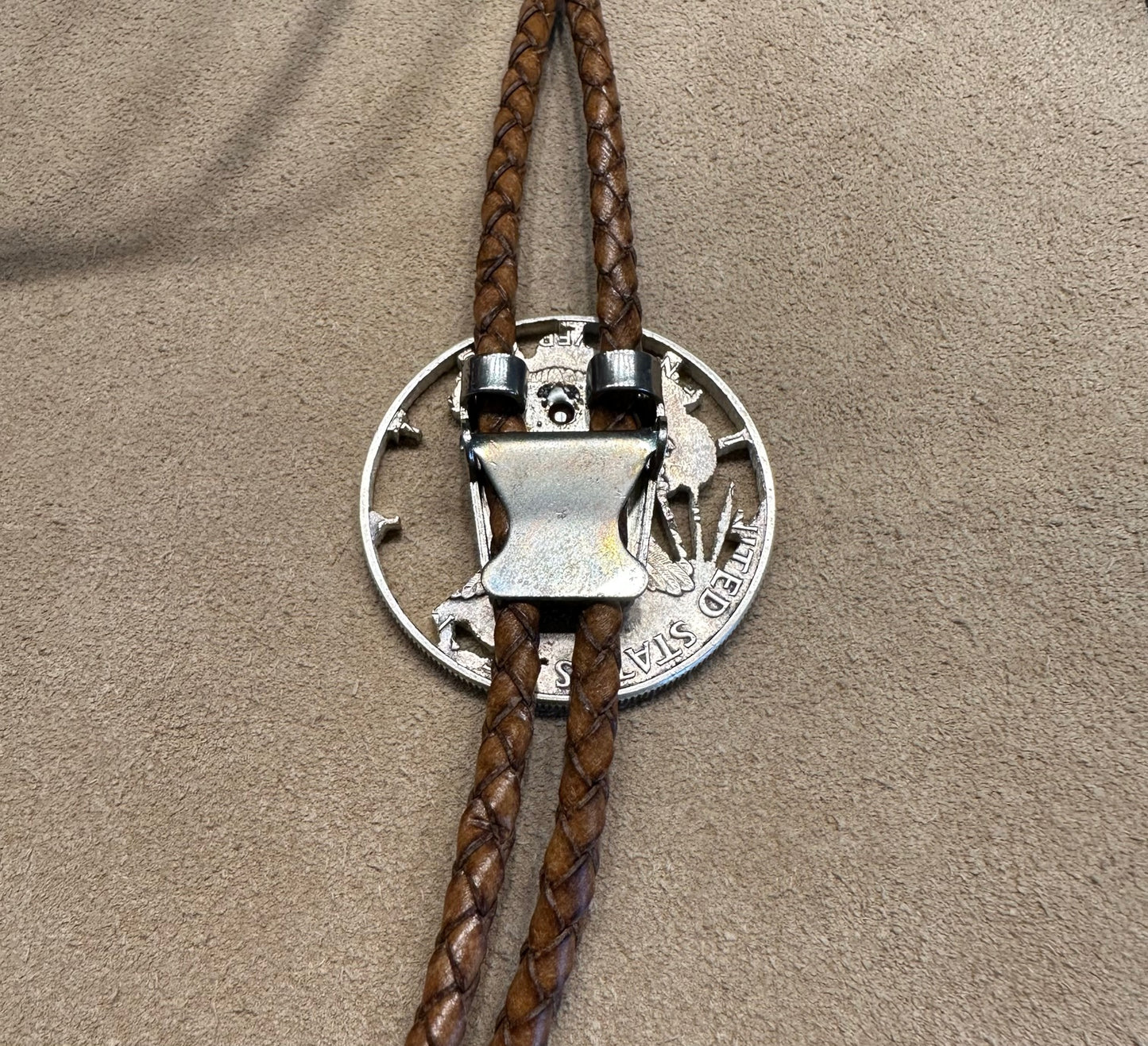 U.S. Silver Eagle Hand Cut Coin Bolo Tie close up on clasp on a light cloth background. - Mountainstruck Coin Jewelry