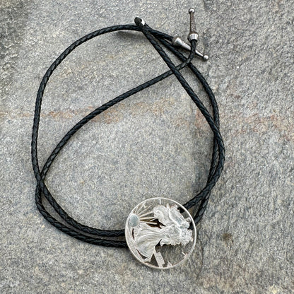 U.S. Silver Eagle Hand Cut Coin Bolo Tie on a grey rock surface. - Mountainstruck Coin Jewelry