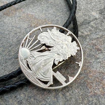 U.S. Silver Eagle Hand Cut Coin Bolo Tie on a grey rock surface. - Mountainstruck Coin Jewelry