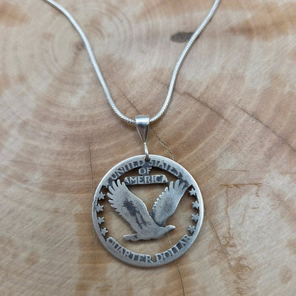 U.S. Soaring Eagle Quarter Hand Cut Silver Coin Necklace on a wood background. - Mountainstruck Coin Jewelry