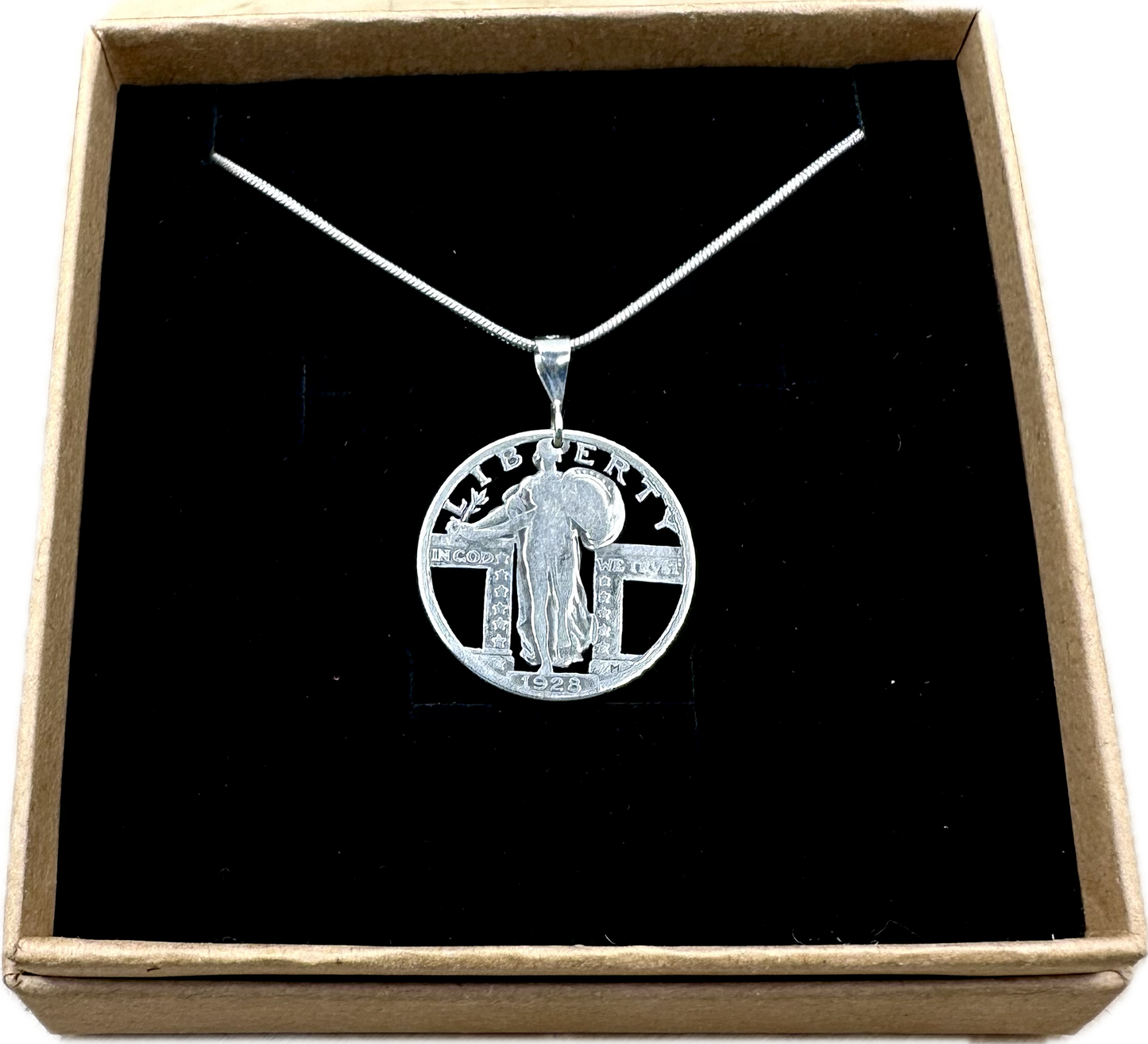 U.S. Standing Liberty Quarter Hand Cut Silver Coin Necklace back in a brown kraft box on a black velvet background. - Mountainstruck Coin Jewelry