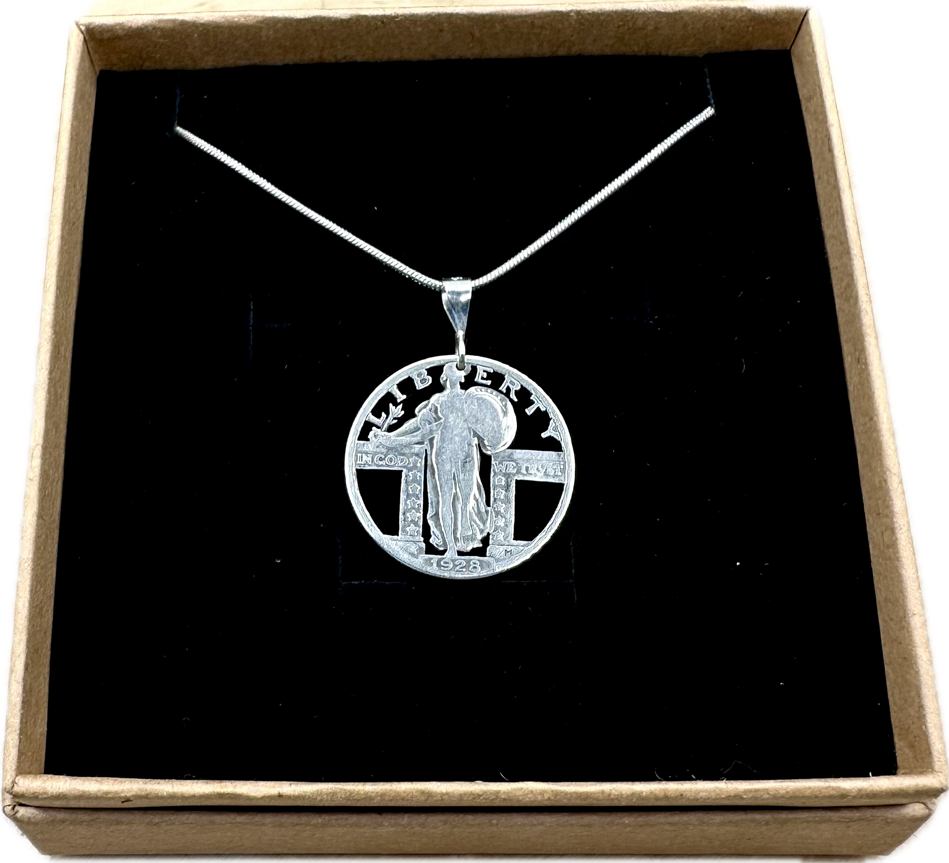 U.S. Standing Liberty Quarter Hand Cut Silver Coin Necklace back in a brown kraft box on a black velvet background. - Mountainstruck Coin Jewelry