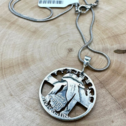 U.S. Standing Liberty Quarter Hand Cut Silver Coin Necklace back on a light wood round. - Mountainstruck Coin Jewelry