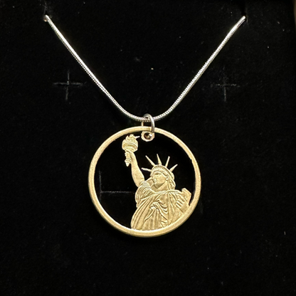 U.S. Statue of Liberty Dollar Hand Cut Coin Necklace with a snake chain in a brown kraft box on a black velvet background. - Mountainstruck Coin Jewelry