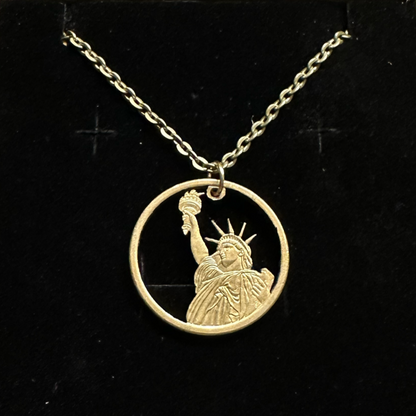 U.S. Statue of Liberty Gold Dollar Hand Cut Coin Necklace with a stainless chain on a black velvet background. - Mountainstruck Coin Jewelry