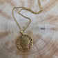 U.S. "V" Nickel Hand Cut Coin Necklace with a stainless chain with a wood background. - Mountainstruck Coin Jewelry