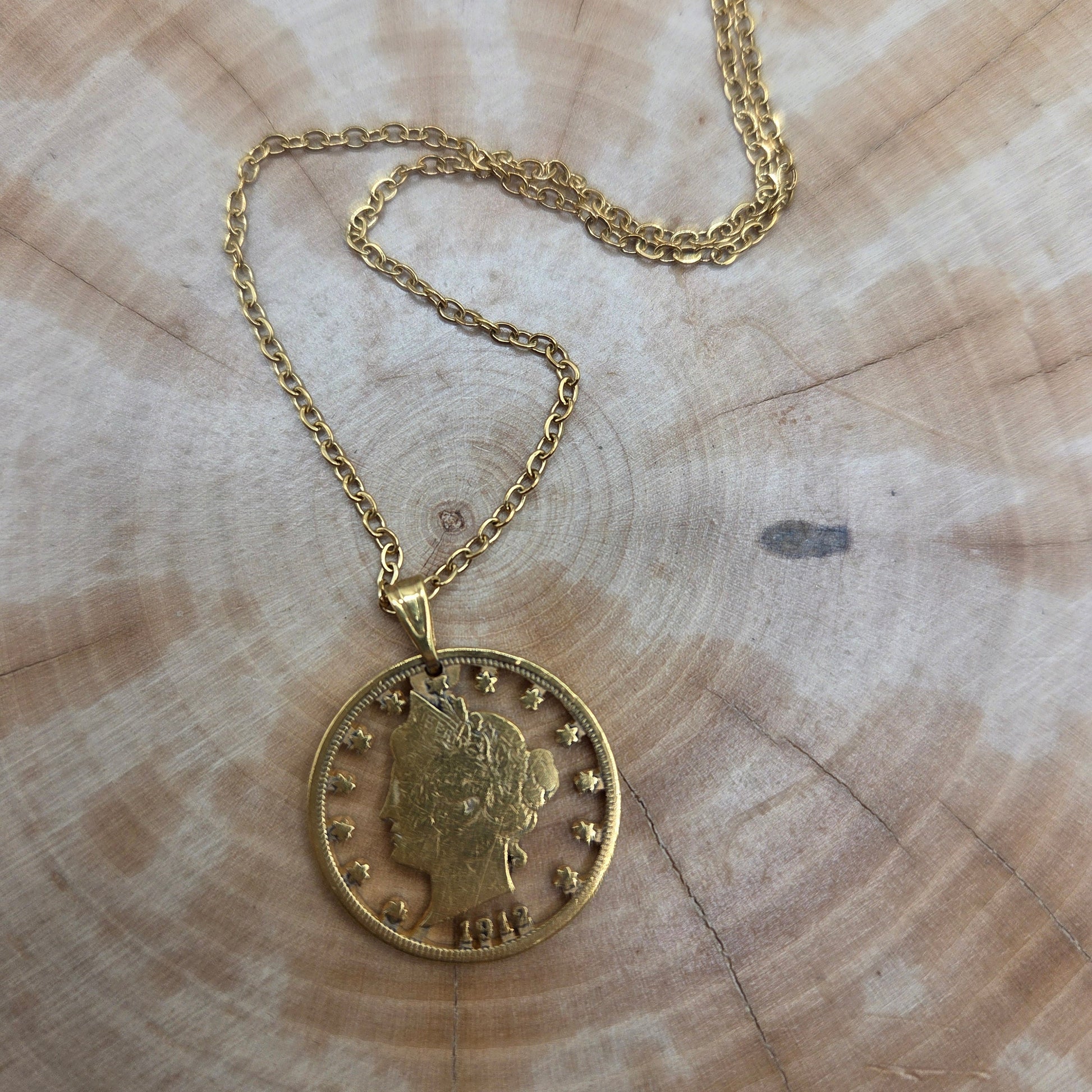 U.S. "V" Nickel Hand Cut Coin Necklace with a stainless chain with a wood background. - Mountainstruck Coin Jewelry