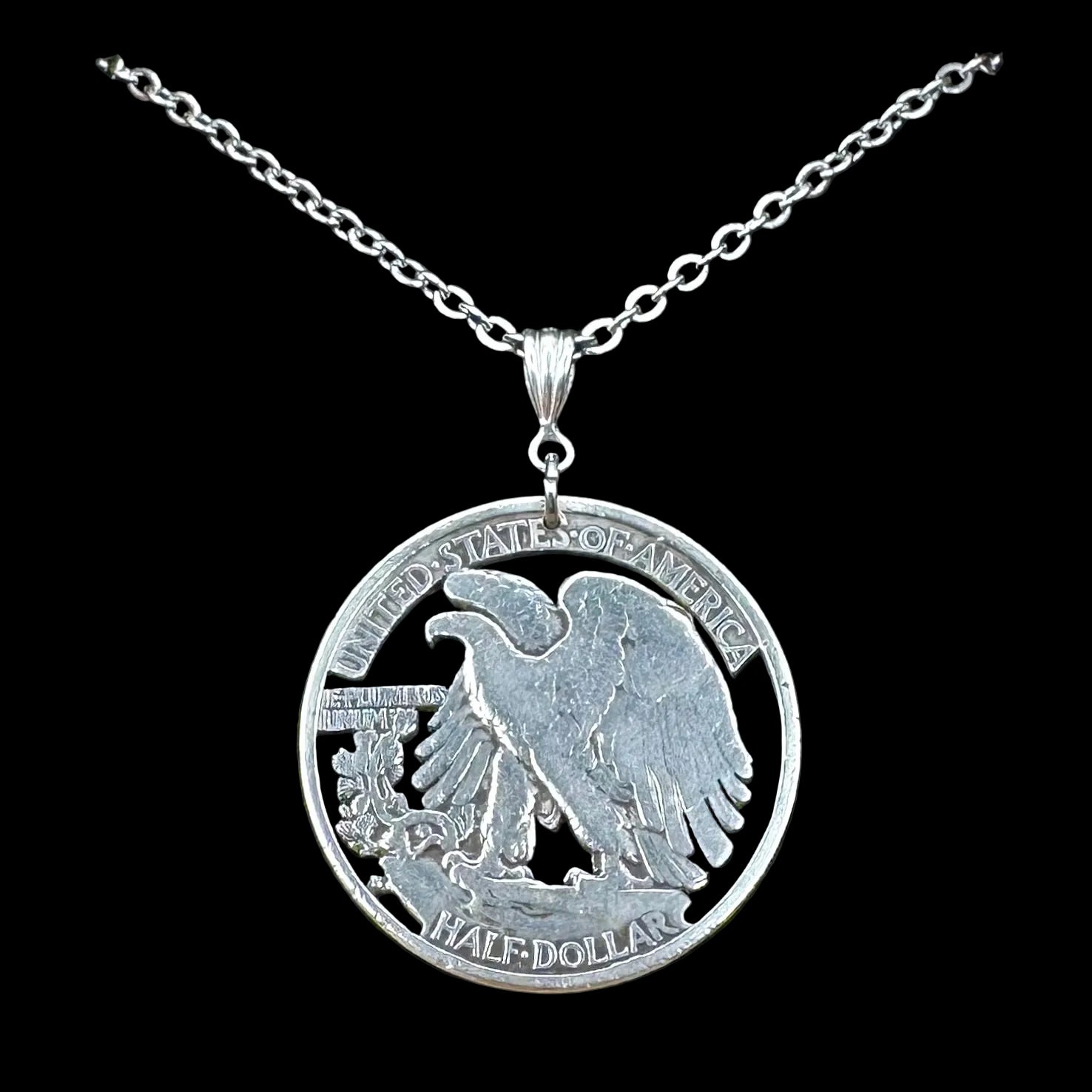 U.S. Walking Liberty Silver Hand Cut Coin Necklace (Eagle) with a stainless chain in a brown kraft box on a black velvet background. - Mountainstruck Coin Jewelry