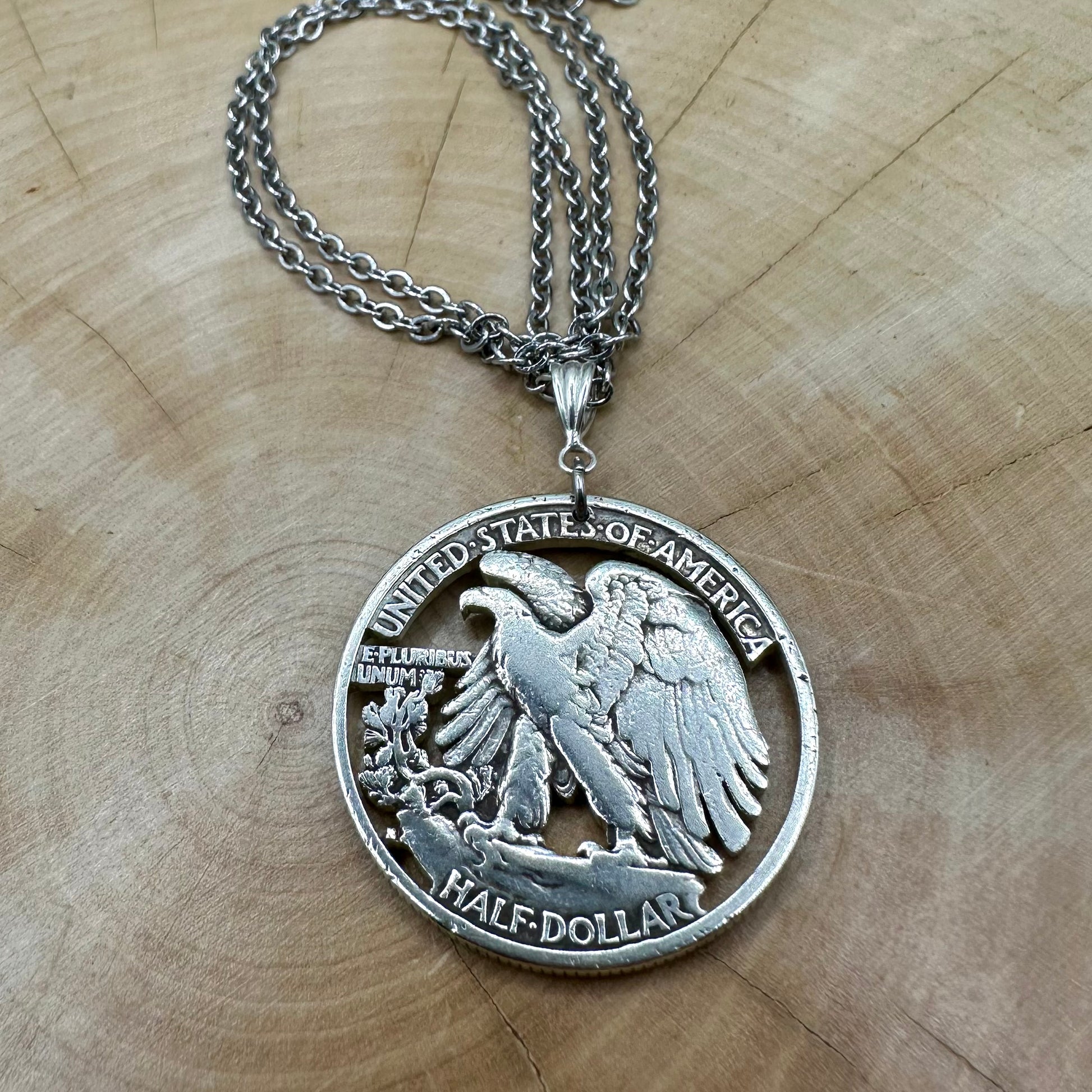 U.S. Walking Liberty Silver Hand Cut Coin Necklace (Eagle) with a snake chain on a light wood background. - Mountainstruck Coin Jewelry