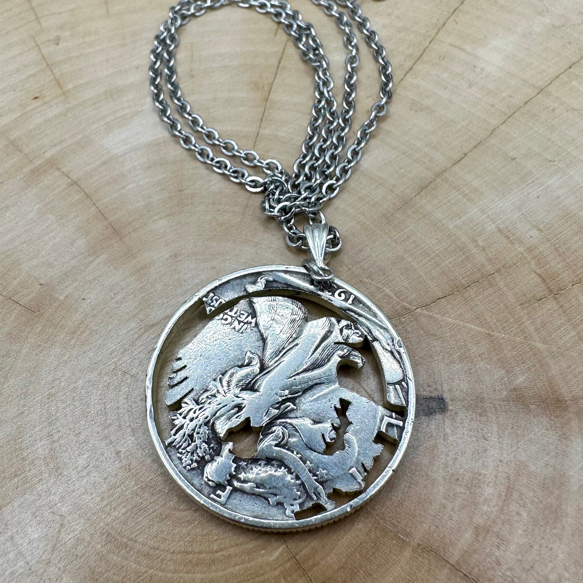 U.S. Walking Liberty Silver Hand Cut Coin Necklace (Eagle) back with a stainless chain on a light wood background. - Mountainstruck Coin Jewelry