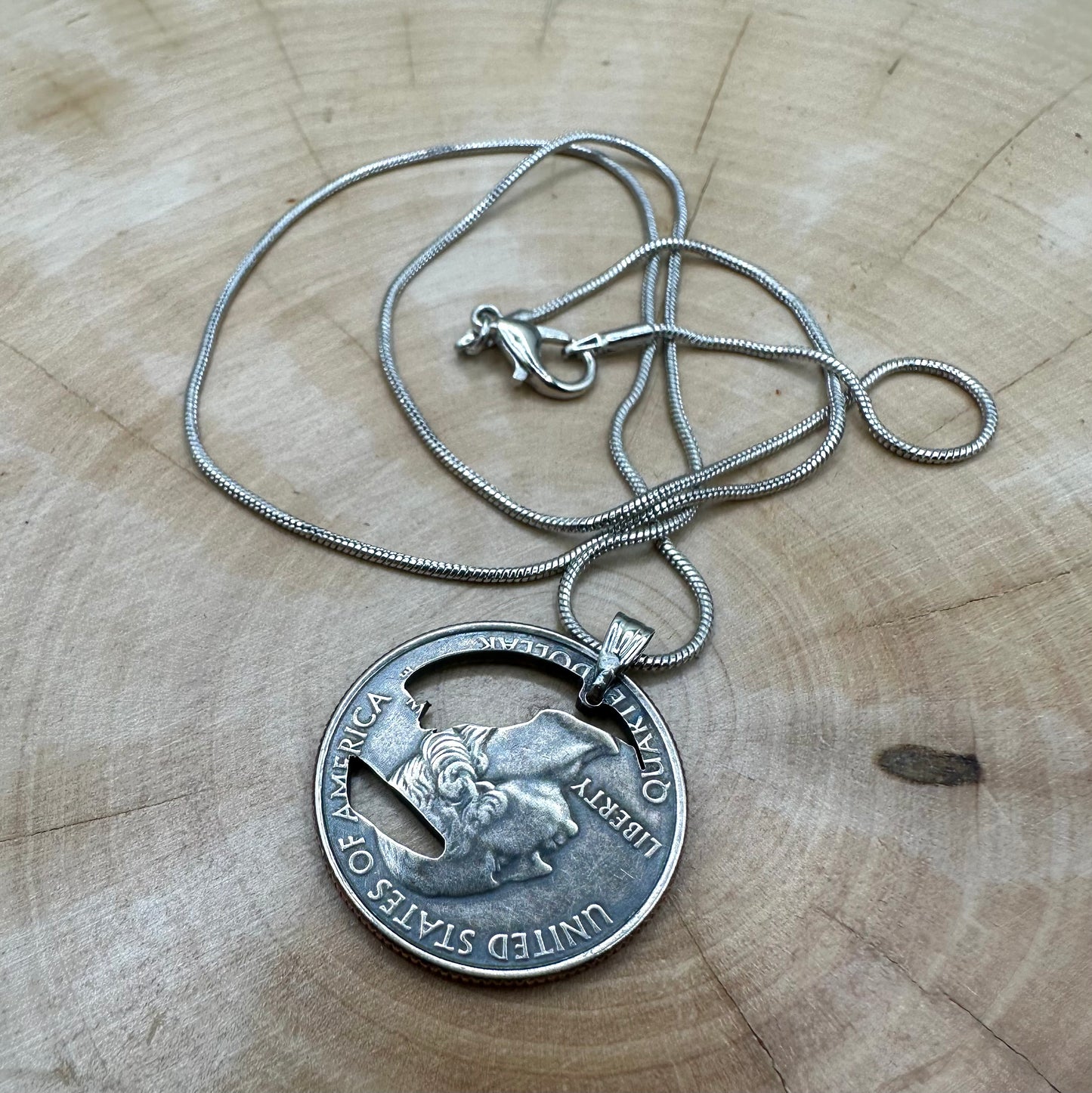 U.S. Yosemite National Park Quarter Hand Cut Coin Necklace back with snake chain on a light wood round. - Mountainstruck Coin Jewelry