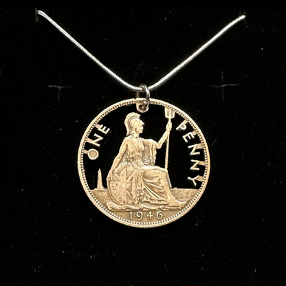UK One Penny Hand Cut Coin Necklace with a snake chain in a brown kraft box on a black velvet background. - Mountainstruck Coin Jewelry