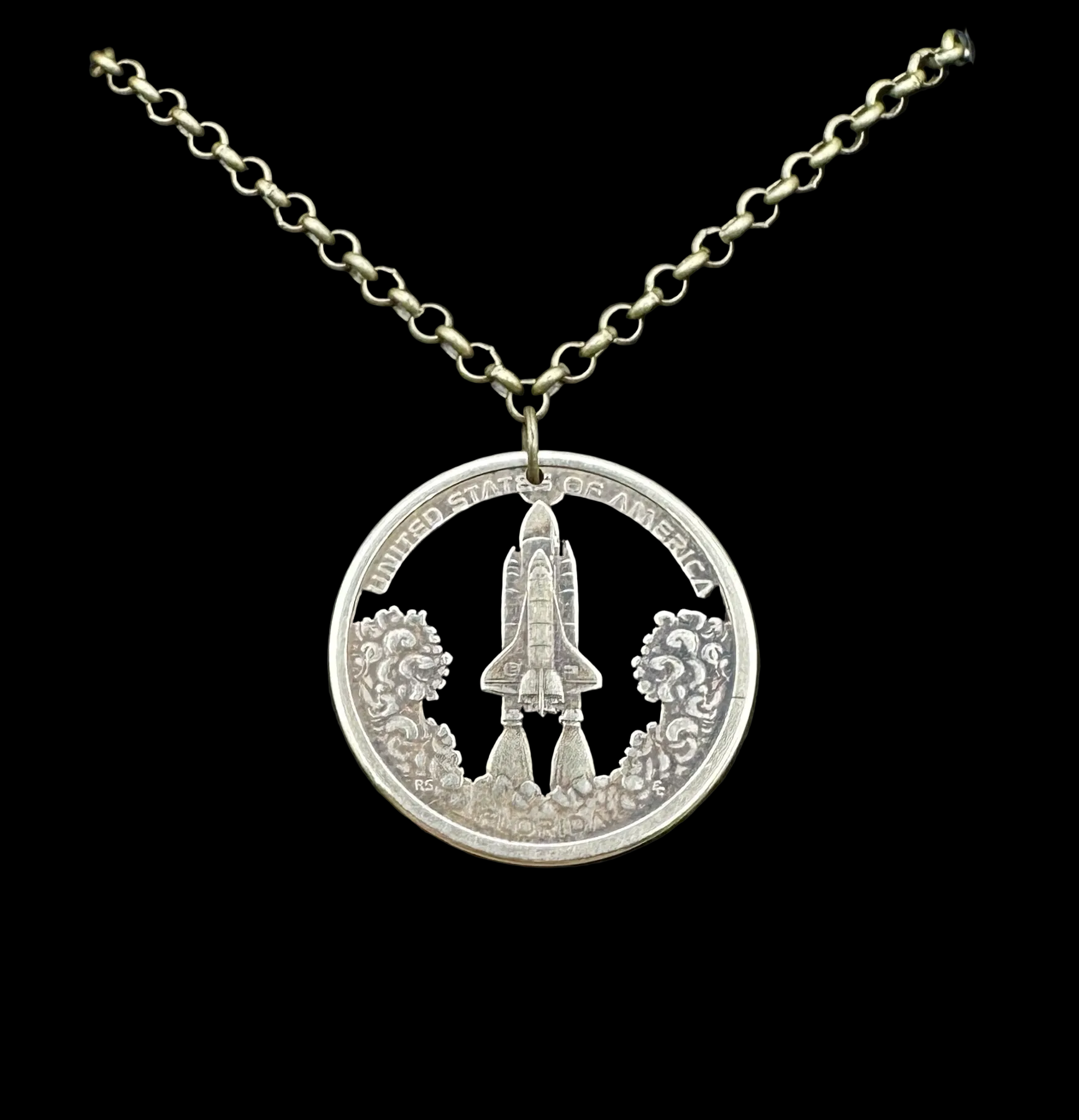 American Innovation $1 Florida Space Shuttle Hand Cut Coin Necklace on a black velvet background. - Mountainstruck Coin Jewelry