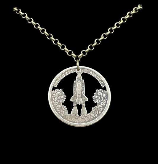 American Innovation $1 Florida Space Shuttle Hand Cut Coin Necklace on a black velvet background. - Mountainstruck Coin Jewelry