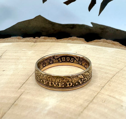 22k U.S. Gold Half Eagle $5 Coin Ring in a light wood round with metal mountains in the background. - Mountainstruck Coin Jewelry