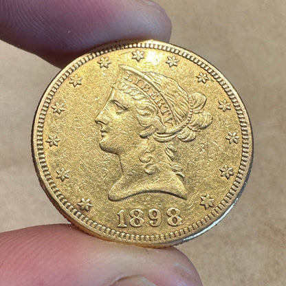 22k U.S. Gold Eagle $10 Coin front held over a light tan cloth. - Mountainstruck Coin Jewelry