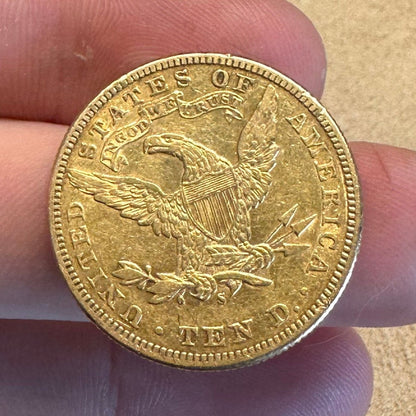 22k U.S. Gold Eagle $10 Coin back held over a light tan cloth. - Mountainstruck Coin Jewelry