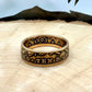 22k U.S. Gold Eagle $10 Coin Ring on a light wood round with a metal mountain background. - Mountainstruck Coin Jewelry