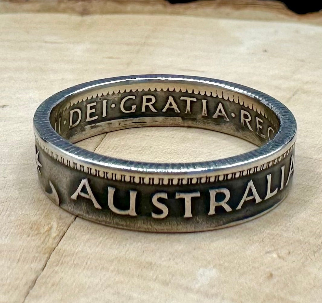 Australia Shilling Silver Coin Ring on light wood round with a metal mountain background. - Mountainstruck Coin Jewelry
