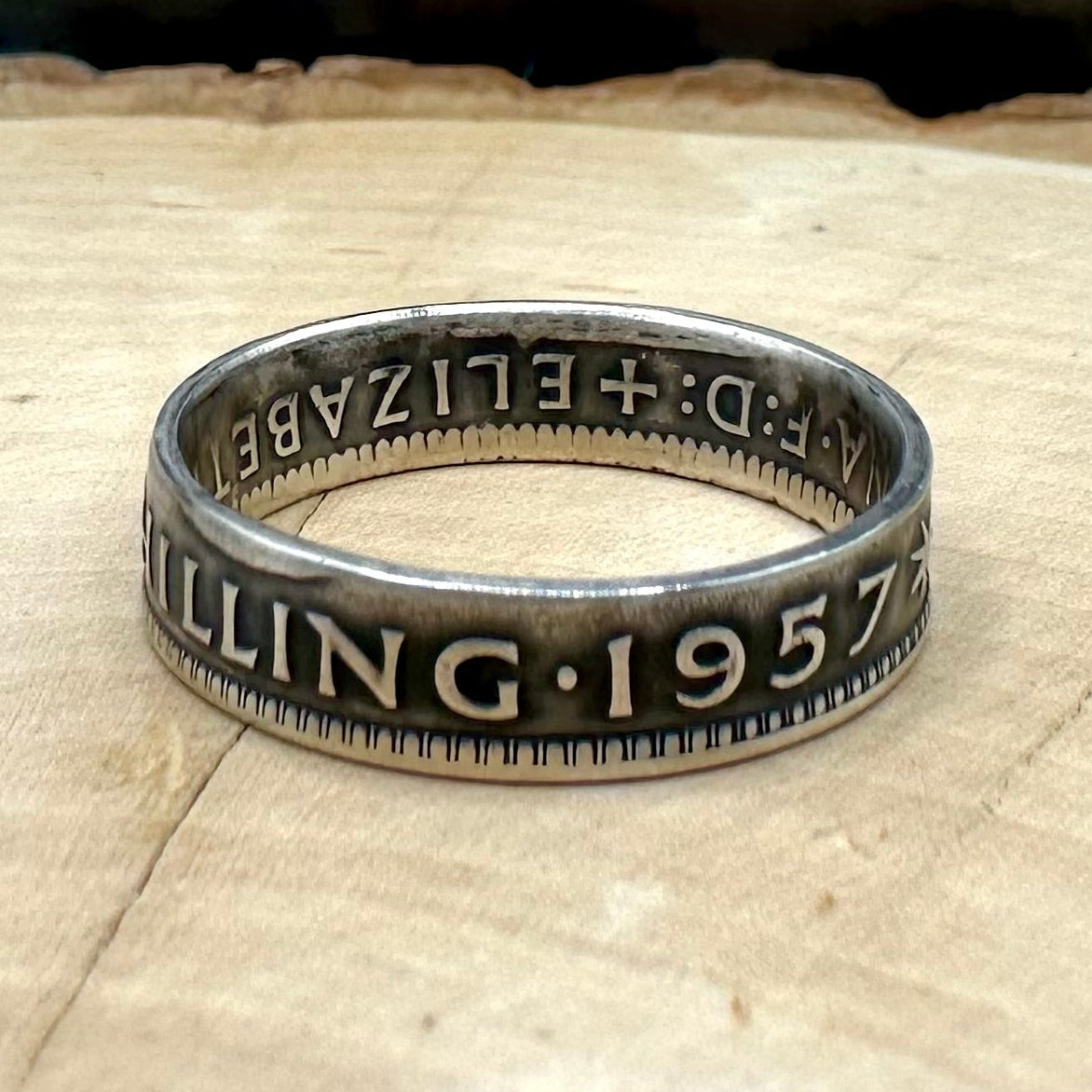 Australia Shilling Silver Coin Ring on light wood round with a metal mountain background. - Mountainstruck Coin Jewelry
