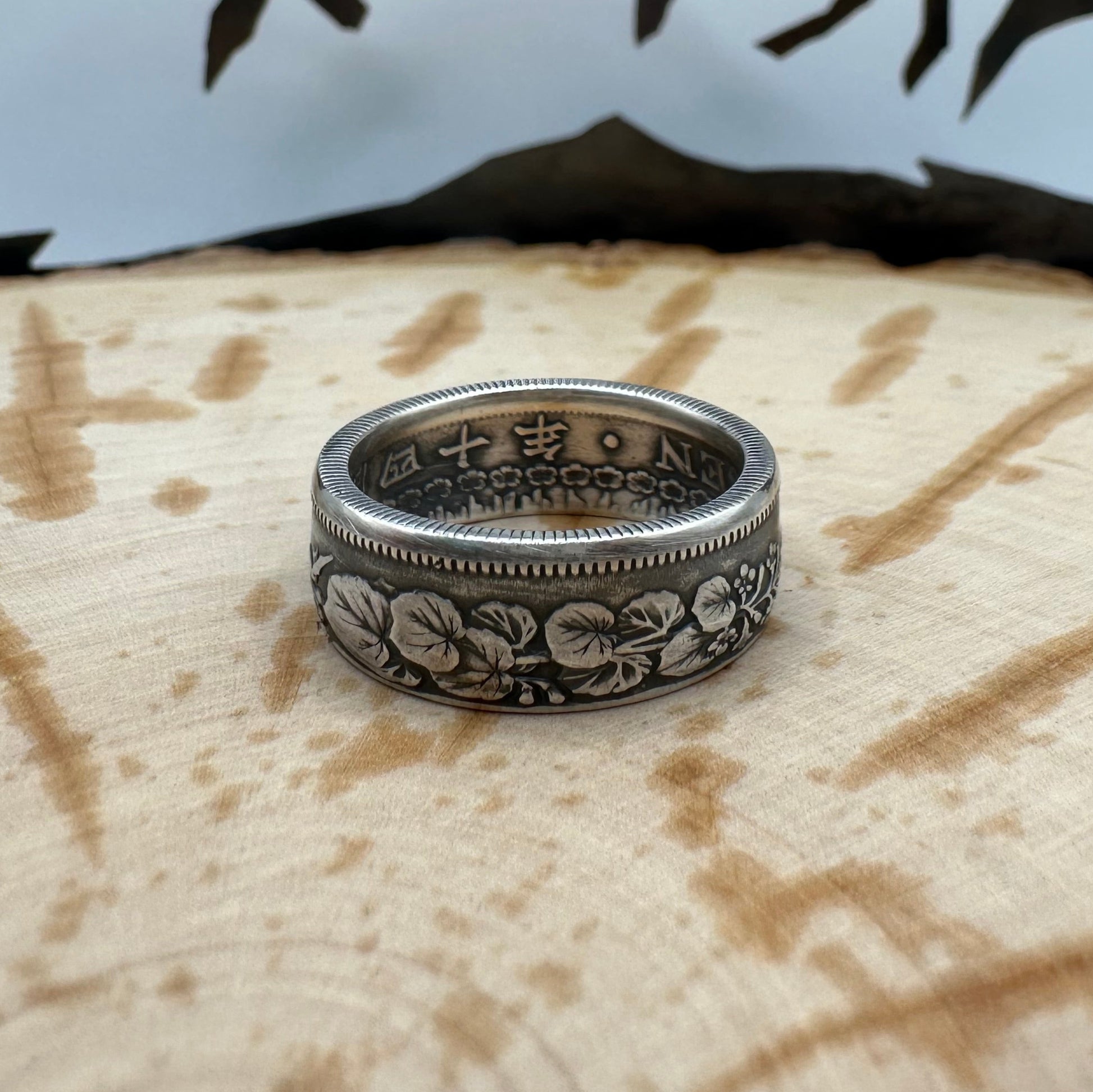 Japan 50 Sen Silver Coin Ring on a wood background. - Mountainstruck Coin Jewelry