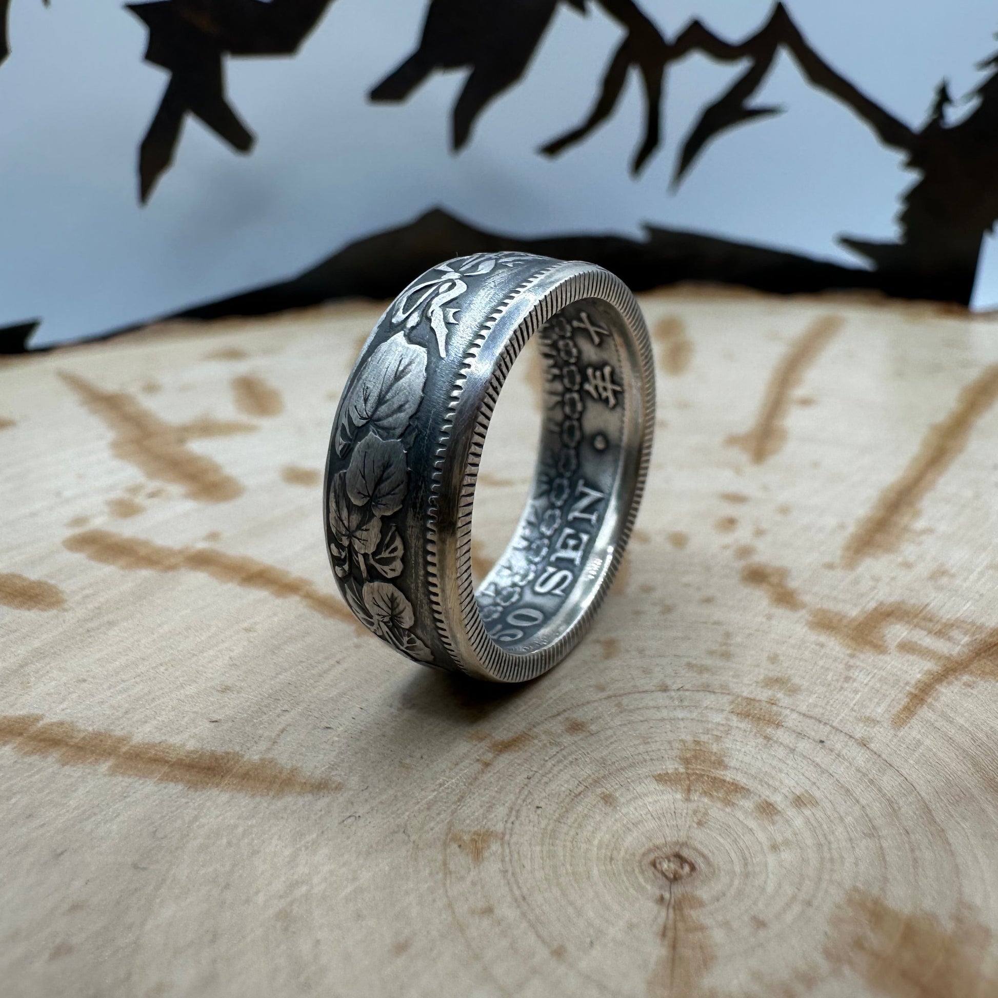 Japan 50 Sen Silver Coin Ring on a wood background. - Mountainstruck Coin Jewelry