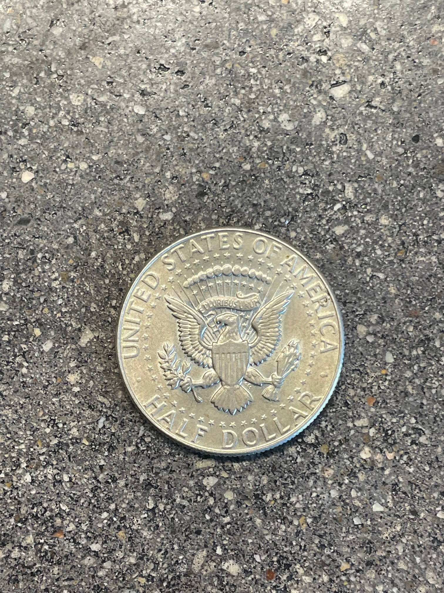 JFK Silver Half Dollar Coin (reverse) on a concrete background - Mountainstruck Coin Jewelry