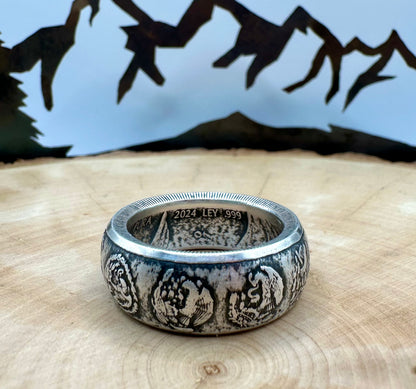 Mexico 1oz Libertad .999 Silver Coin Ring on a light wood round with a metal mountain background. - Mountainstruck Coin Jewelry