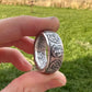 Mexico 1oz Libertad .999 Silver Coin Ring held on its side in front green grass. - Mountainstruck Coin Jewelry