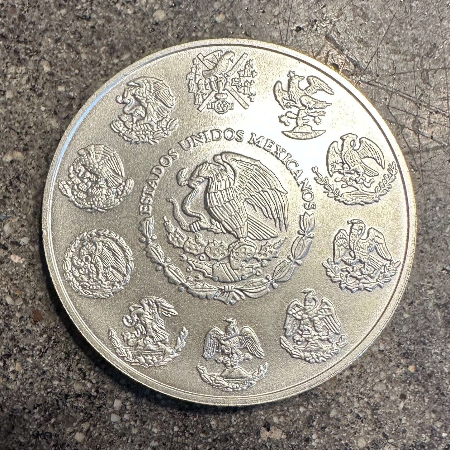 Mexico 1oz Libertad .999 Silver Coin back on a concrete surface. - Mountainstruck Coin Jewelry