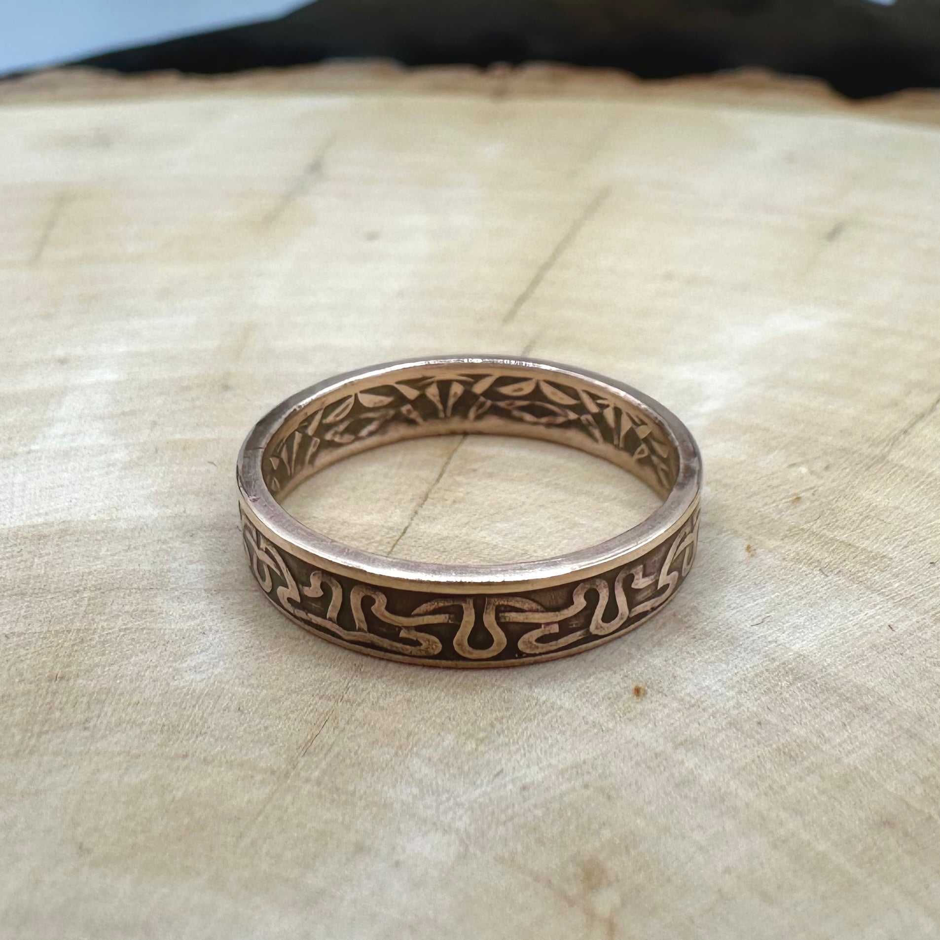 Suriname 1 Cent Coin Ring on a light wood round. - Mountainstruck Coin Jewelry