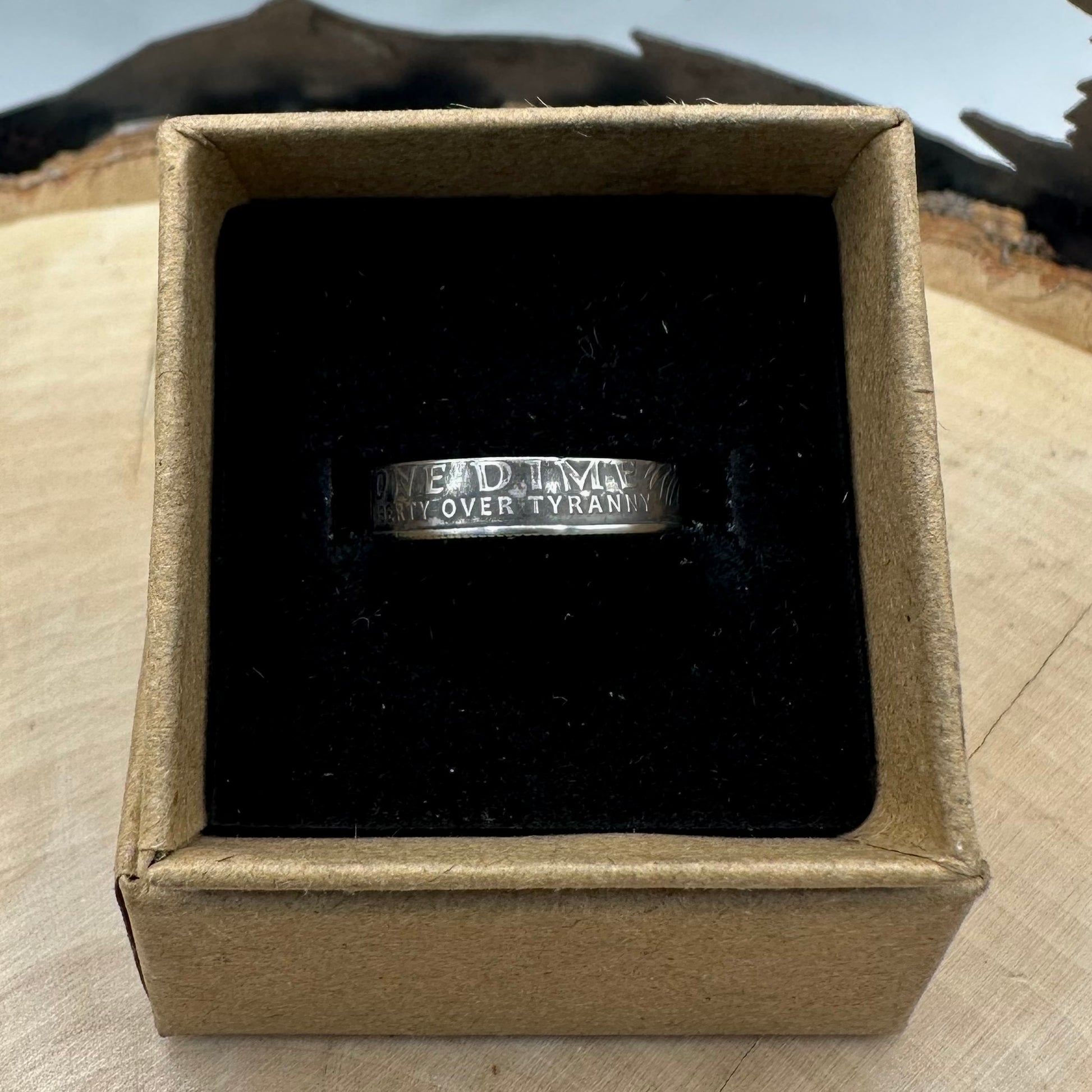 U.S. 2026 "Liberty Over Tyranny" Dime Coin Ring on a black velvet background in a brown kraft box on a wood round. -Mountainstruck Coin Jewelry