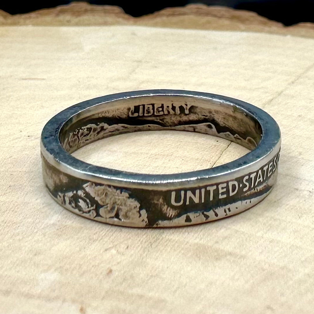 U.S. Buffalo Nickel Coin Ring on a light wood round with a metal mountain background. - Mountainstruck Coin Jewelry