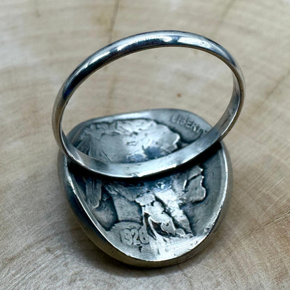 U.S. Buffalo Nickel Coin Signet Ring (Buffalo Side) with a sterling silver band on a light wood round with a metal mountain background. - Mountainstruck Coin Jewelry