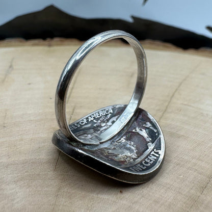 U.S. Buffalo Nickel Coin Signet Ring (Native side) with a sterling silver band on a light wood round with a metal mountain background. - Mountainstruck Coin Jewelry