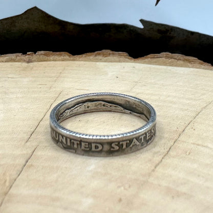 U.S. Dime Coin Ring on a light wood round with a metal mountain background. - Mountainstruck Coin Jewelry